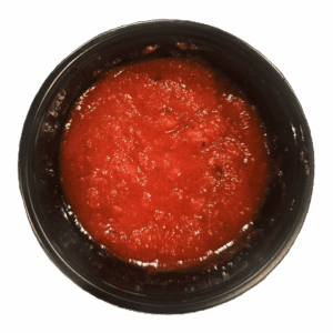 A black container filled with red tomato sauce, viewed from above, on a white background.