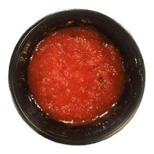 A black container filled with red tomato sauce, viewed from above, on a white background.